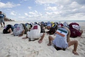 Attivisti del Sierra Club mostrano l'atteggiamento delle nazioni nei confronti del cambiamento climatico: mettere la testa dentro la sabbia 